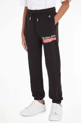 Zdjęcie produktu Calvin Klein Jeans spodnie dresowe bawełniane dziecięce kolor czarny z nadrukiem