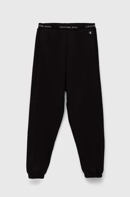Zdjęcie produktu Calvin Klein Jeans spodnie dresowe dziecięce kolor czarny gładkie
