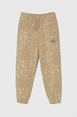Zdjęcie produktu Calvin Klein Jeans spodnie dresowe bawełniane dziecięce kolor beżowy wzorzyste