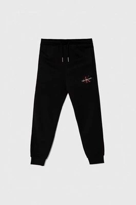 Zdjęcie produktu Calvin Klein Jeans spodnie dresowe bawełniane dziecięce kolor czarny z nadrukiem