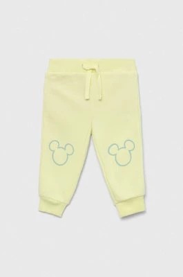 Zdjęcie produktu GAP spodnie dresowe dziecięce x Disney kolor żółty z nadrukiem Gap